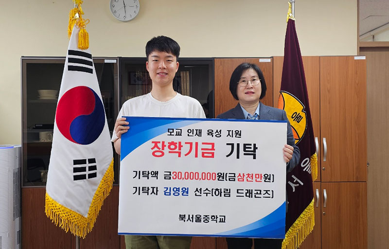 김영원(왼쪽)이 17일 모교 북서울중학교에서 기탁식을 가진 후 정영순 교장(오른쪽)과 기념 촬영 하고 있다..jpg
